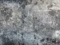Texture d'une vieille dalle de béton, marquée par le temps et le salpêtre.