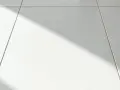 Laitance sur carrelage blanc, une ombre diagonale traverse la scène. Comment enlever laitance carrelage naturellement ?