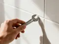 Main tenant, une clé à molette pour enlever du joint de carrelage sec.
