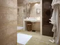 Salle de bain moderne avec carrelage imitation travertin. Un nettoyage à la vapeur serait idéal pour maintenir cette finition.