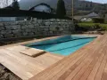 Piscine en bois avec terrasse en bois, mur de soutènement en pierre. Entretien piscine bois facile avec cette belle installation.