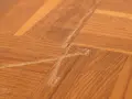 Parquet vitrifié abîmé par des frottements, montrant des marques et des éclats de bois. Comment enlever trace de frottement sur parquet vitrifié.