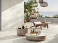 Terrasse avec pose travertin sur carrelage existant. Chaise longue, tables basses et vue mer. Ambiance détente.