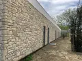 Façade d'un bâtiment moderne avec un revêtement en pierre calcaire construction, créant une esthétique naturelle et robuste.