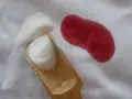 Poudre blanche sur tissu blanc à côté d'une tache rouge. Astuce pour savoir comment enlever des taches de sang sur du coton.