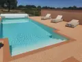 Piscine avec escalier, entourée de **pierre autour piscine** et de chaises longues.