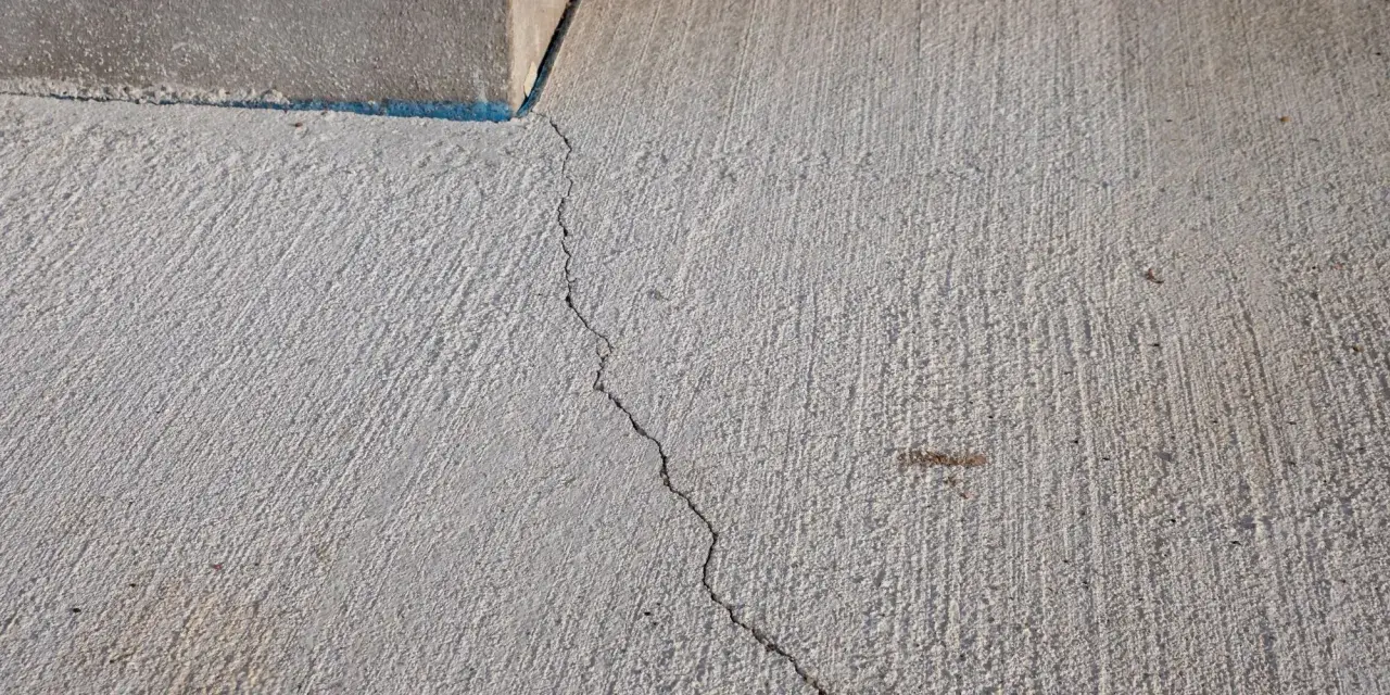 Une fissure traverse une dalle de béton. Cela soulève la question : peut-on couler une dalle en plusieurs fois sans compromettre sa solidité ?