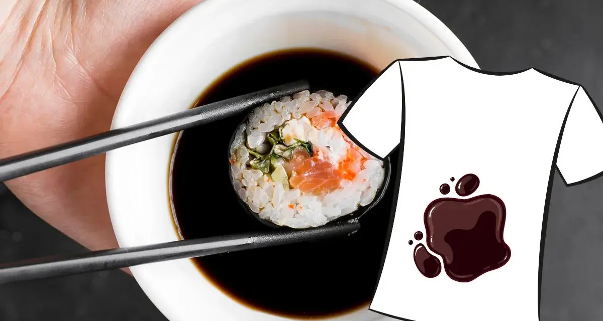 Une main tient une pince à sushi trempant un rouleau dans une sauce soja. Une tache de sauce soja est dessinée sur un t-shirt blanc.
