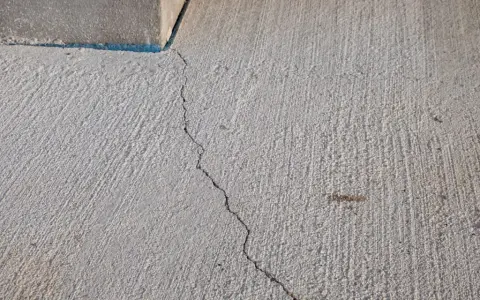 Une fissure traverse une dalle de béton. Cela soulève la question : peut-on couler une dalle en plusieurs fois sans compromettre sa solidité ?
