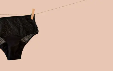 Culotte menstruelle noire en dentelle, suspendue sur une corde à linge. Apprenez comment laver culotte menstruelle pour une utilisation durable.