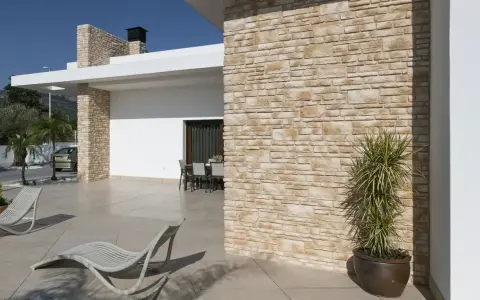 Façade en pierre reconstituée. Ses inconvénients : entretien parfois délicat, risque de décoloration.