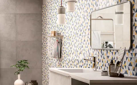 Salle de bain moderne avec mur géométrique coloré. Le primaire d'accrochage pour faïence assure une pose parfaite de ce carrelage audacieux.