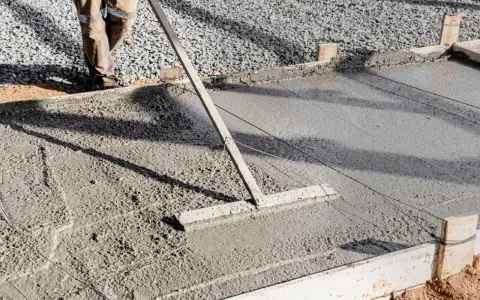 Outil pour aplanir le béton frais, étape clé pour savoir comment faire une dalle de terrasse.