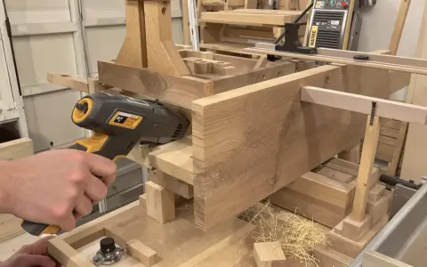 Un artisan utilise un outil pour enlever le saturateur bois d'une pièce de bois massif.
