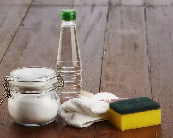 Bicarbonate de soude dans un bocal, une bouteille de vinaigre, une éponge et une brosse à dents. Idéal pour 15 utilisations du bicarbonate de soude.