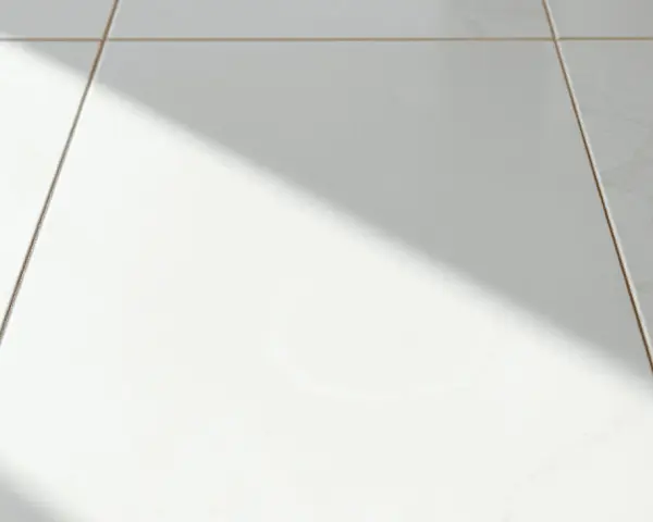 Laitance sur carrelage blanc, une ombre diagonale traverse la scène. Comment enlever laitance carrelage naturellement ?