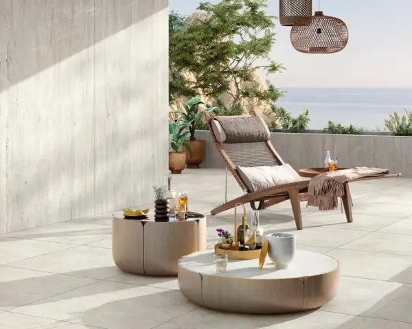 Une **terrasse en travertin** aux tons clairs, avec mobilier de détente et vue mer. Avis : un espace paisible et élégant.