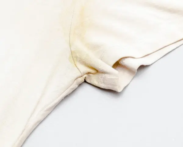 Une tache jaune sur un vêtement blanc, sous le bras, témoigne d'une journée bien remplie.