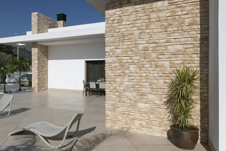 Façade en pierre reconstituée. Ses inconvénients : entretien parfois délicat, risque de décoloration.