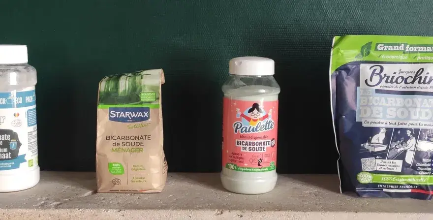 Quatre produits de bicarbonate de soude, dont un pour raviver le noir, sont alignés.