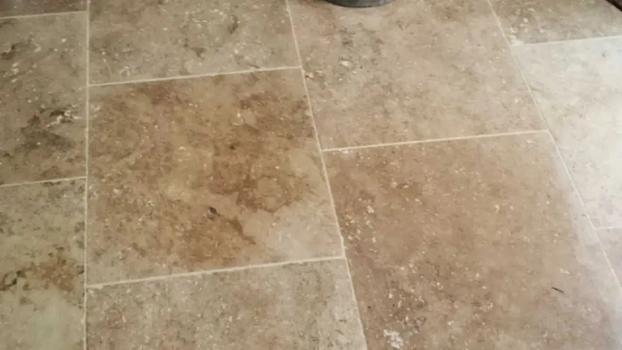 Gros plan sur un sol en travertin, montrant les variations de couleur et de texture des carreaux. Une m&eacute;thode de nettoyage &agrave; la vapeur est id&eacute;ale pour nettoyer le travertin.