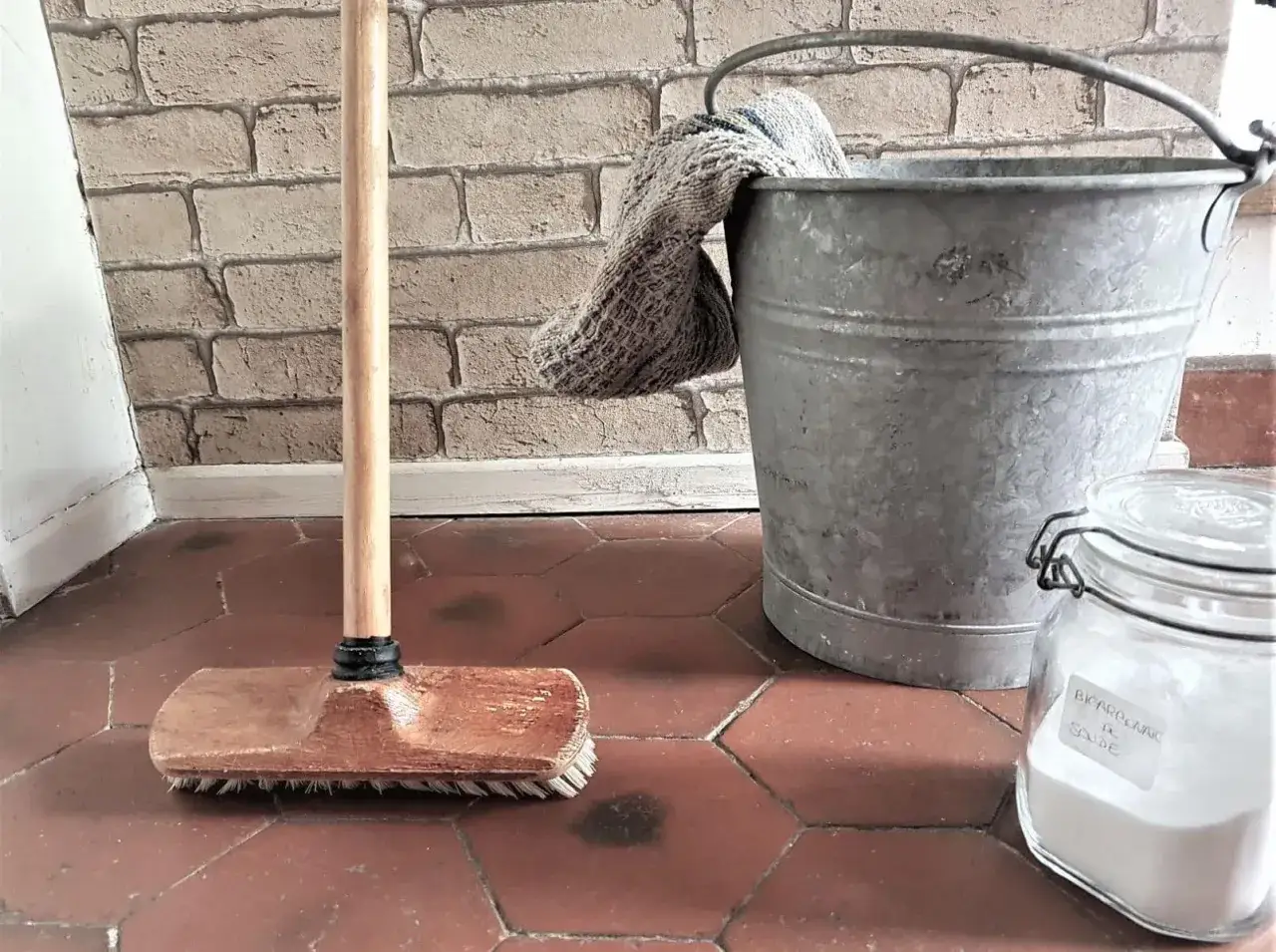 Balai, seau et bocal de bicarbonate de soude : tout pour un nettoyant sol maison efficace et &eacute;cologique.